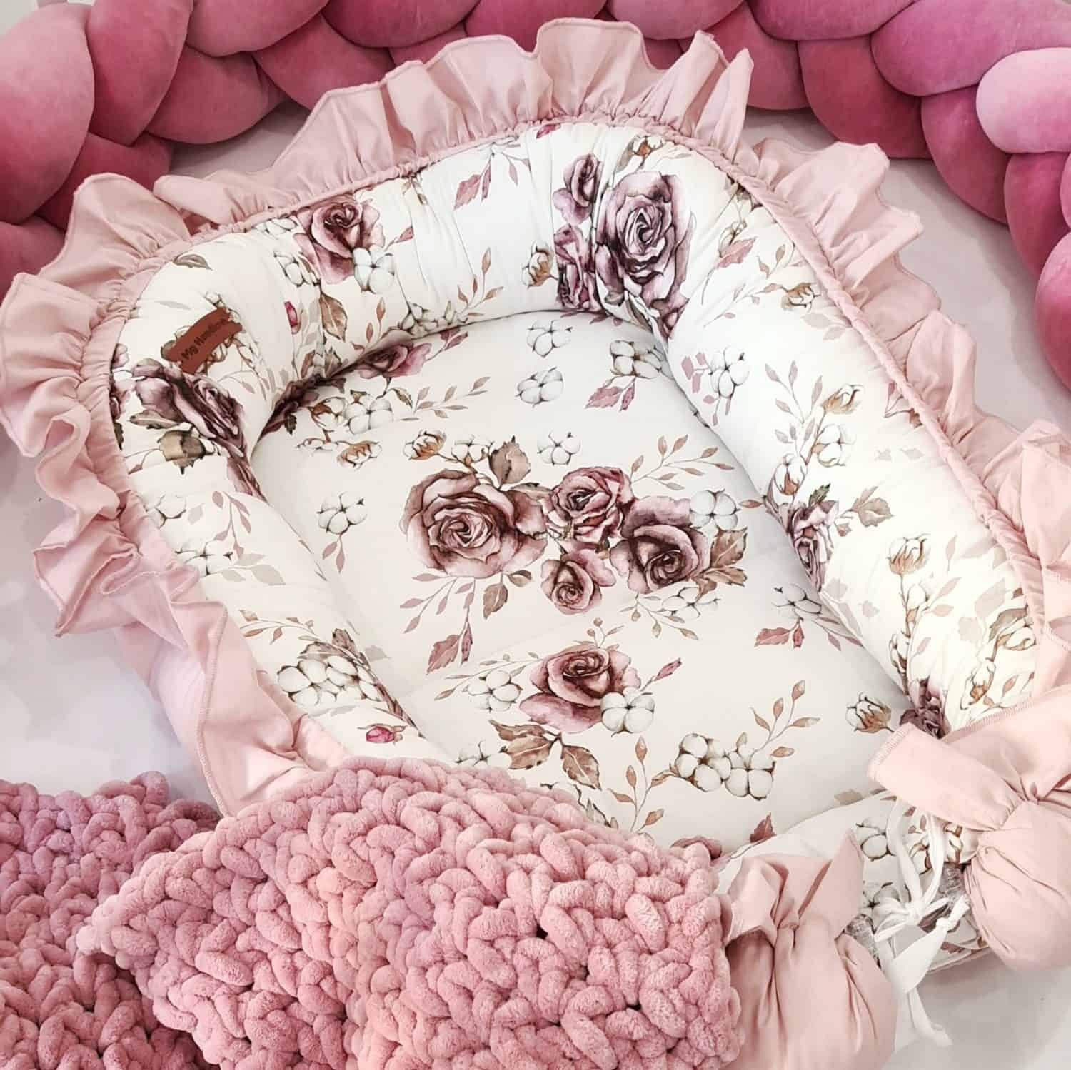 Łóżeczko niemowlaka z pościelą w róże i bawełnę