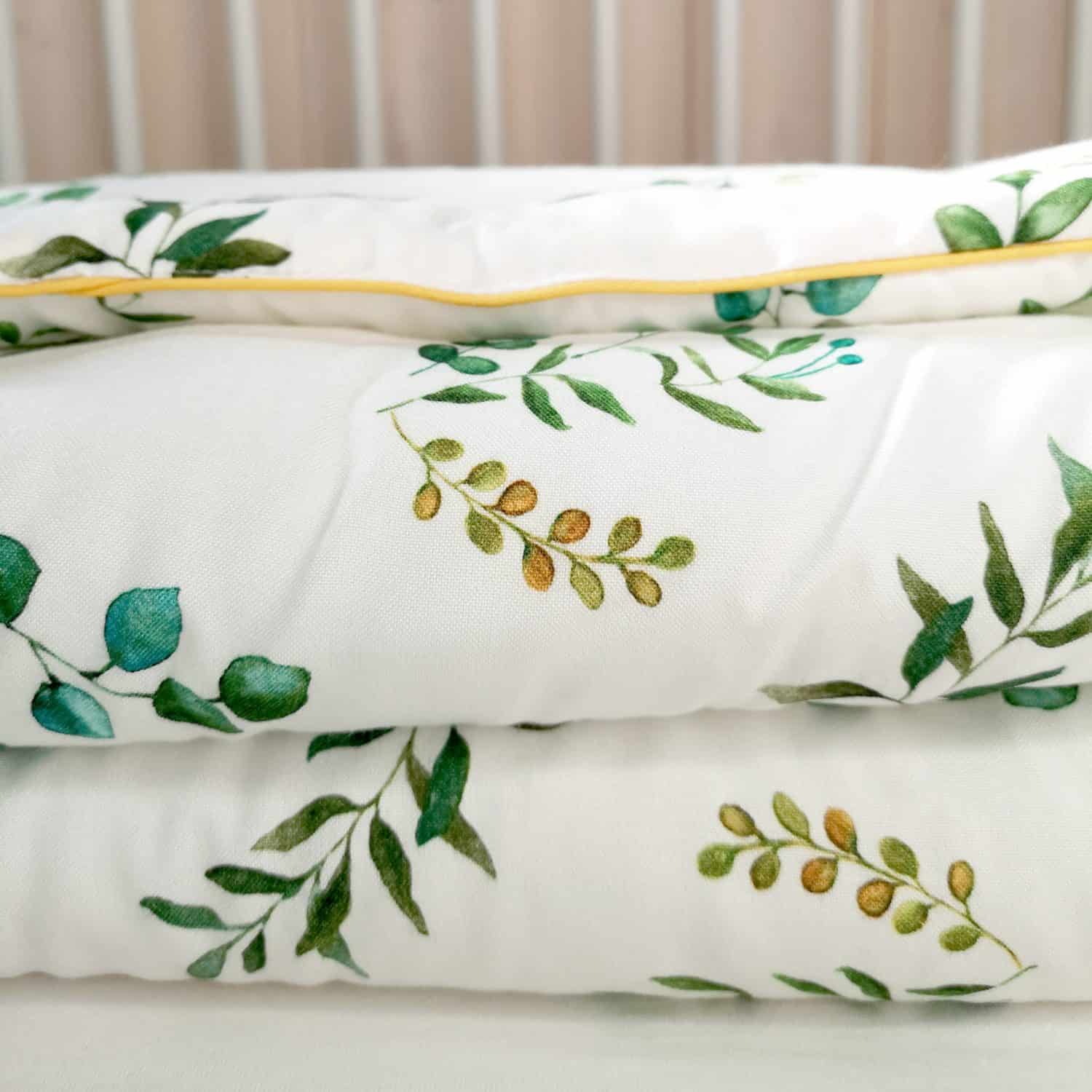 ropa de cama blanca con el estampado de hojas