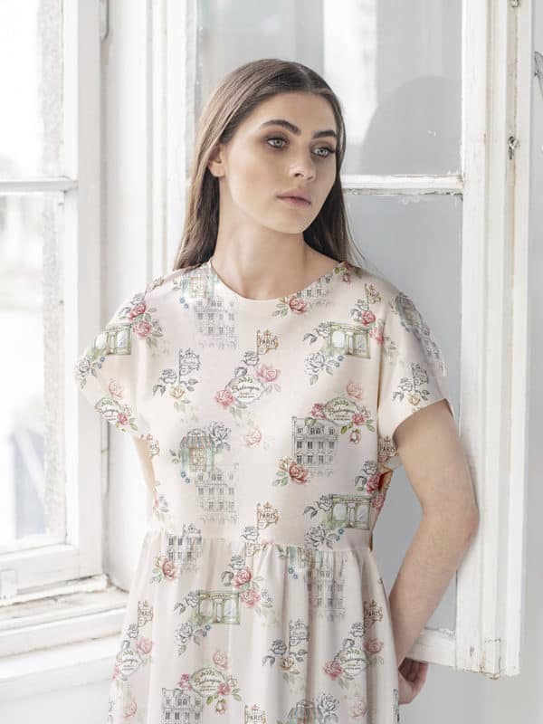 model standing at the window in a romantic dress with seamless pattern design with Parisian streets