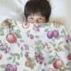 boy in bedding with autumn fruits pattern design